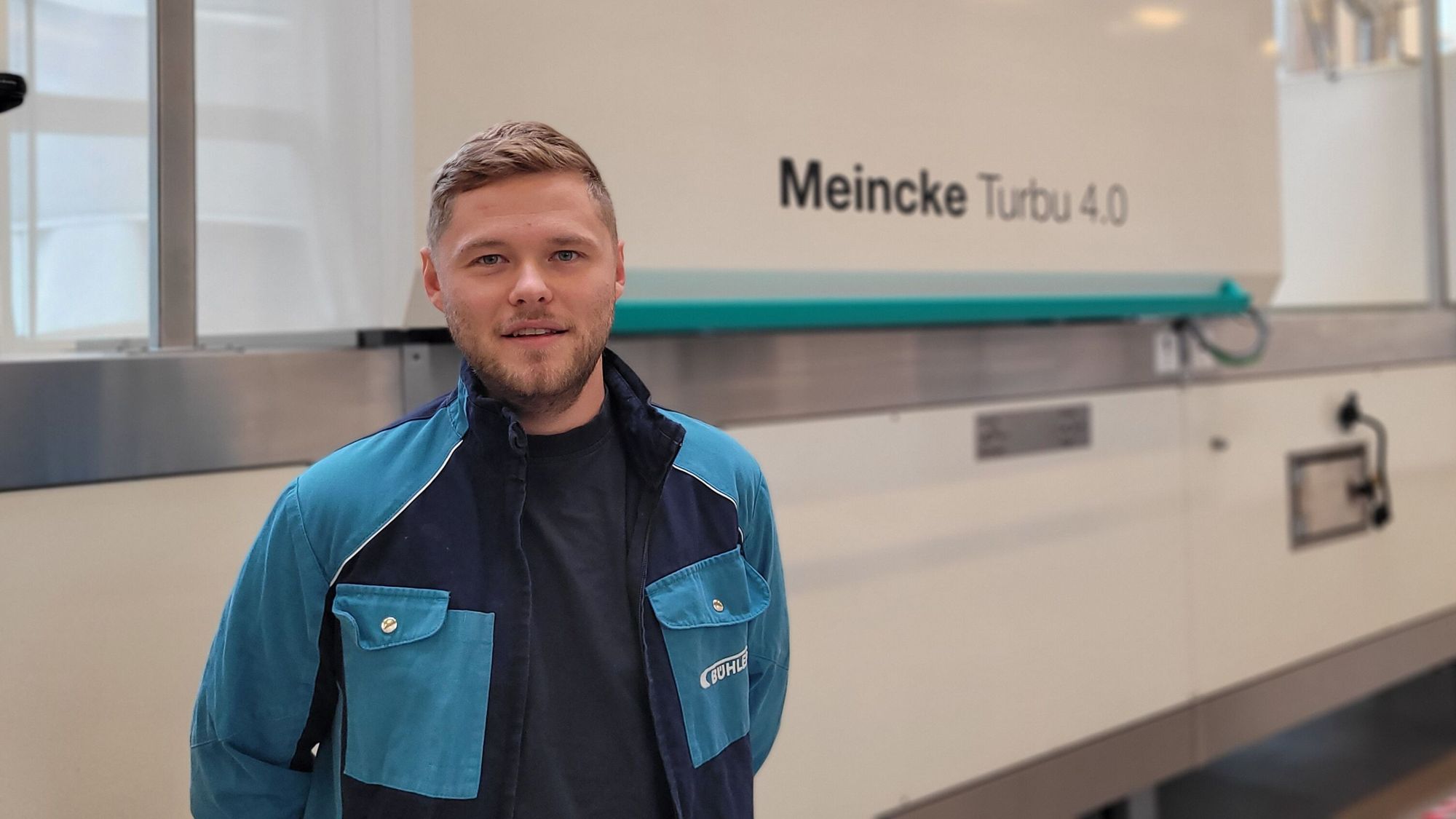 A Bühler employee standing in front of a cookie line.