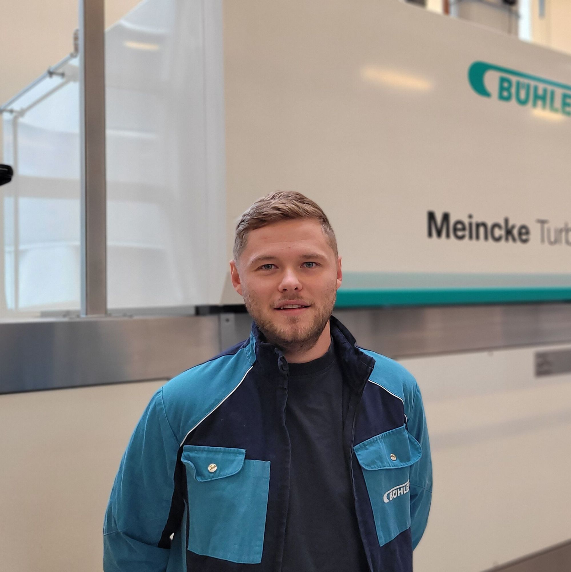 A Bühler employee standing in front of a cookie line.