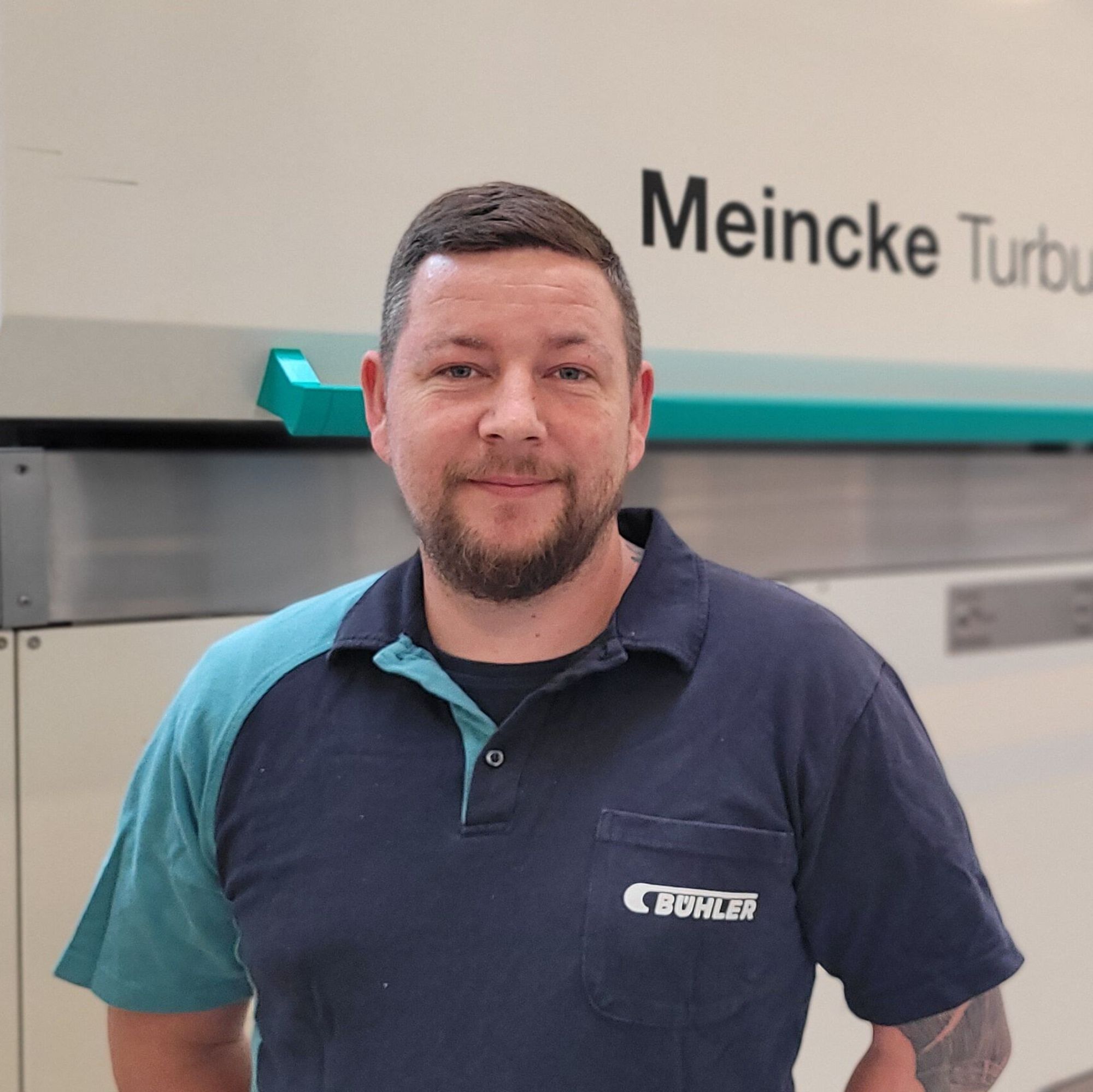A Bühler employee standing in front of a cookie line.