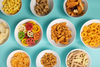 multiple bowls of extruded savory snacks like finger chips, cheetos, pasta shaped snacks