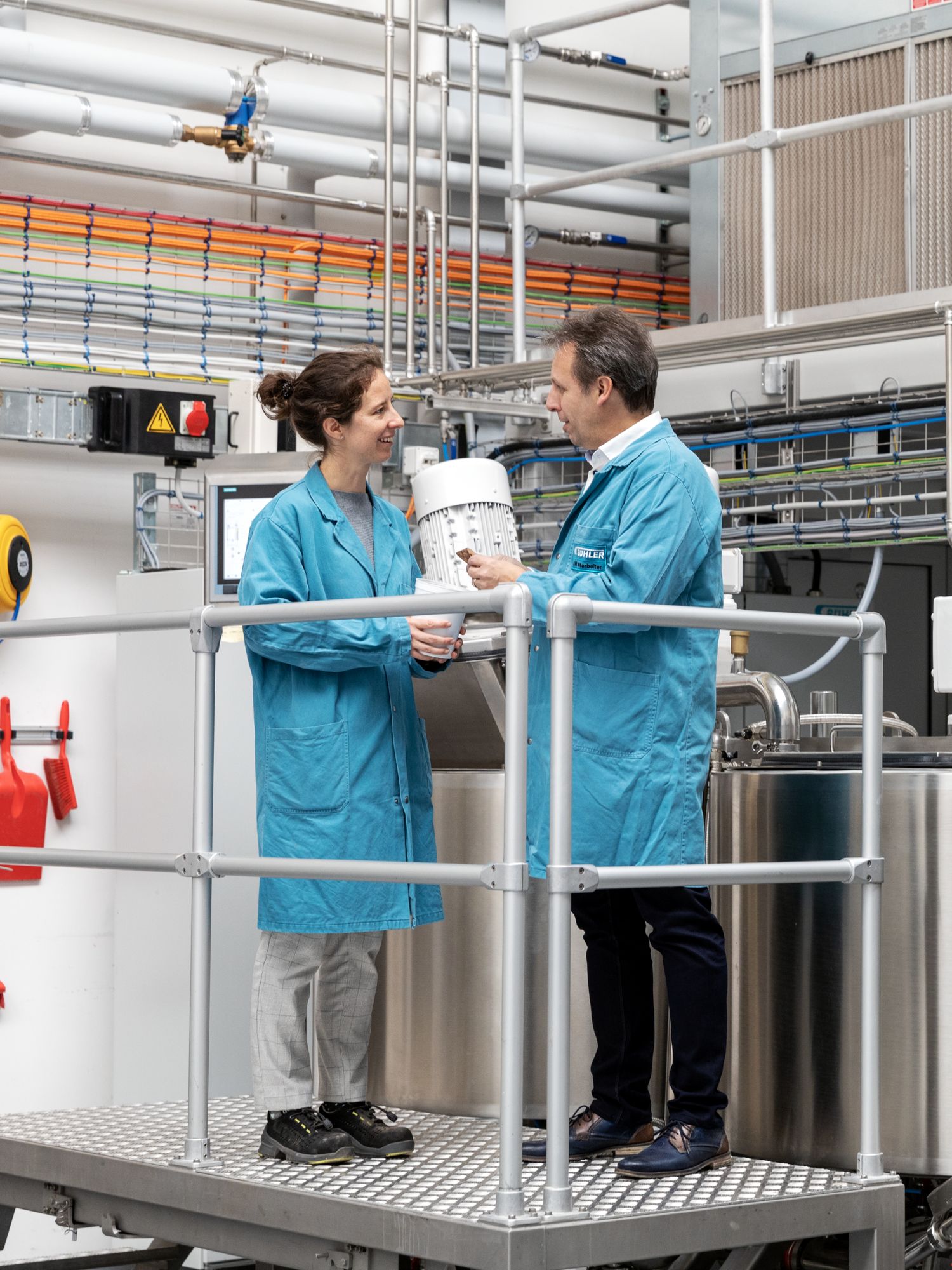 Stefanie Keller, Head of Chocolate Mass, Cocoa, and Nuts Application Center, im Austausch mit Manuel Höhener, Head of R&D Chocolate Mass and Coffee.